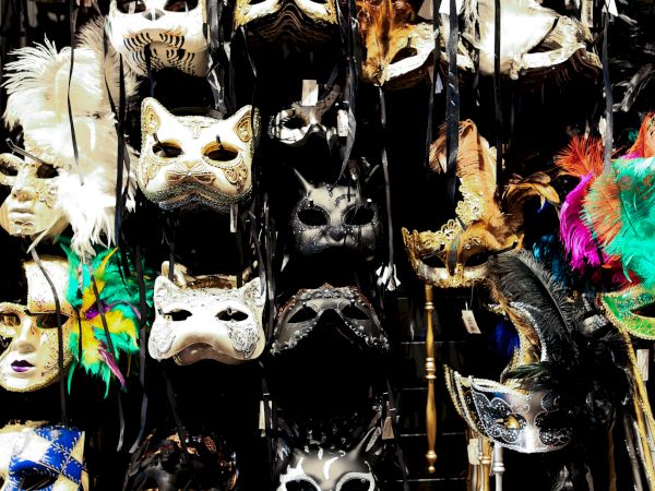A variety of decorative masks with feathers and vibrant colors are displayed, creating an eye-catching and diverse collection.