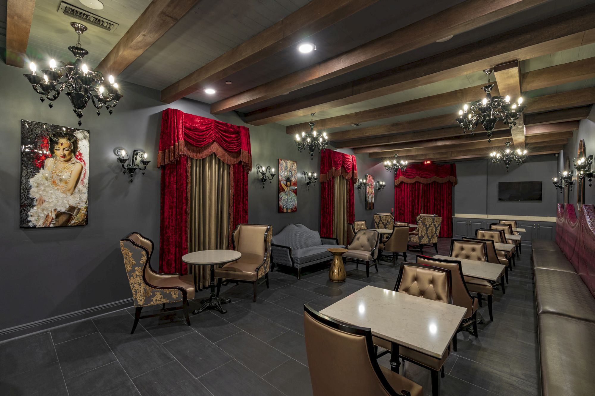 A luxurious lounge with chandeliers, marble tables, and comfortable seating.